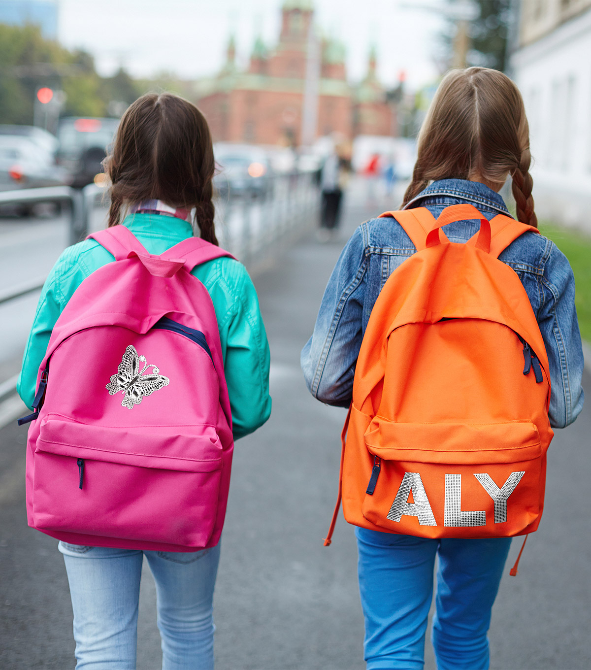 Rhinestone butterfly and letter iron-ons on backpacks